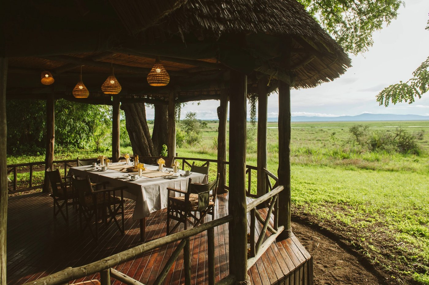 Eettafels gezet op het terras met uitzicht op de vlaktes op Katavi Wildlife Camp