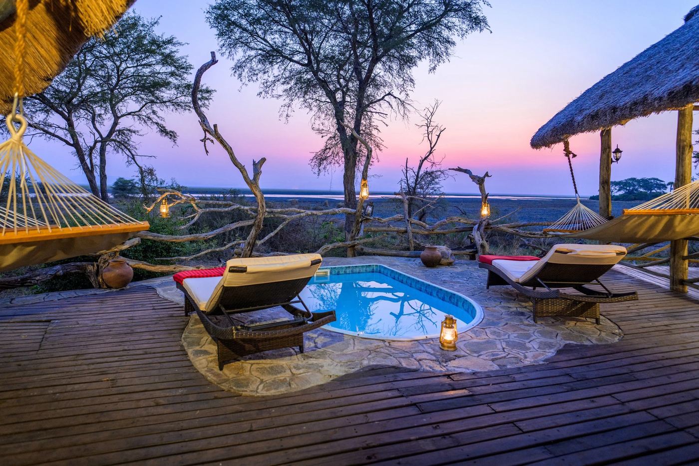 Een zwembad en hangmatten op het terras in de schemering, Katavi Wildlife Camp
