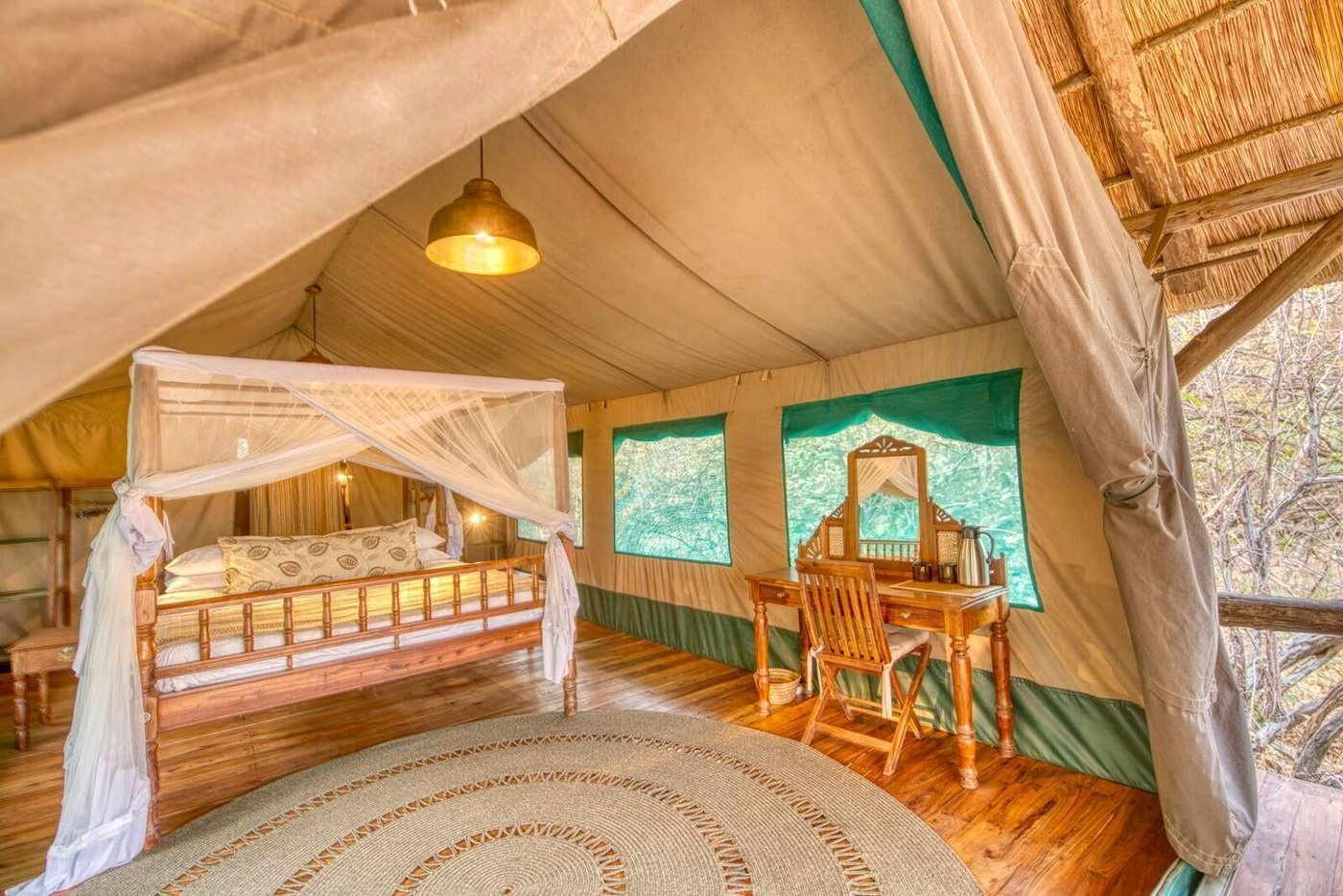 Ein Baldachimbett in einem Zeltzimmer in Mbali Mbali Katavi Lodge