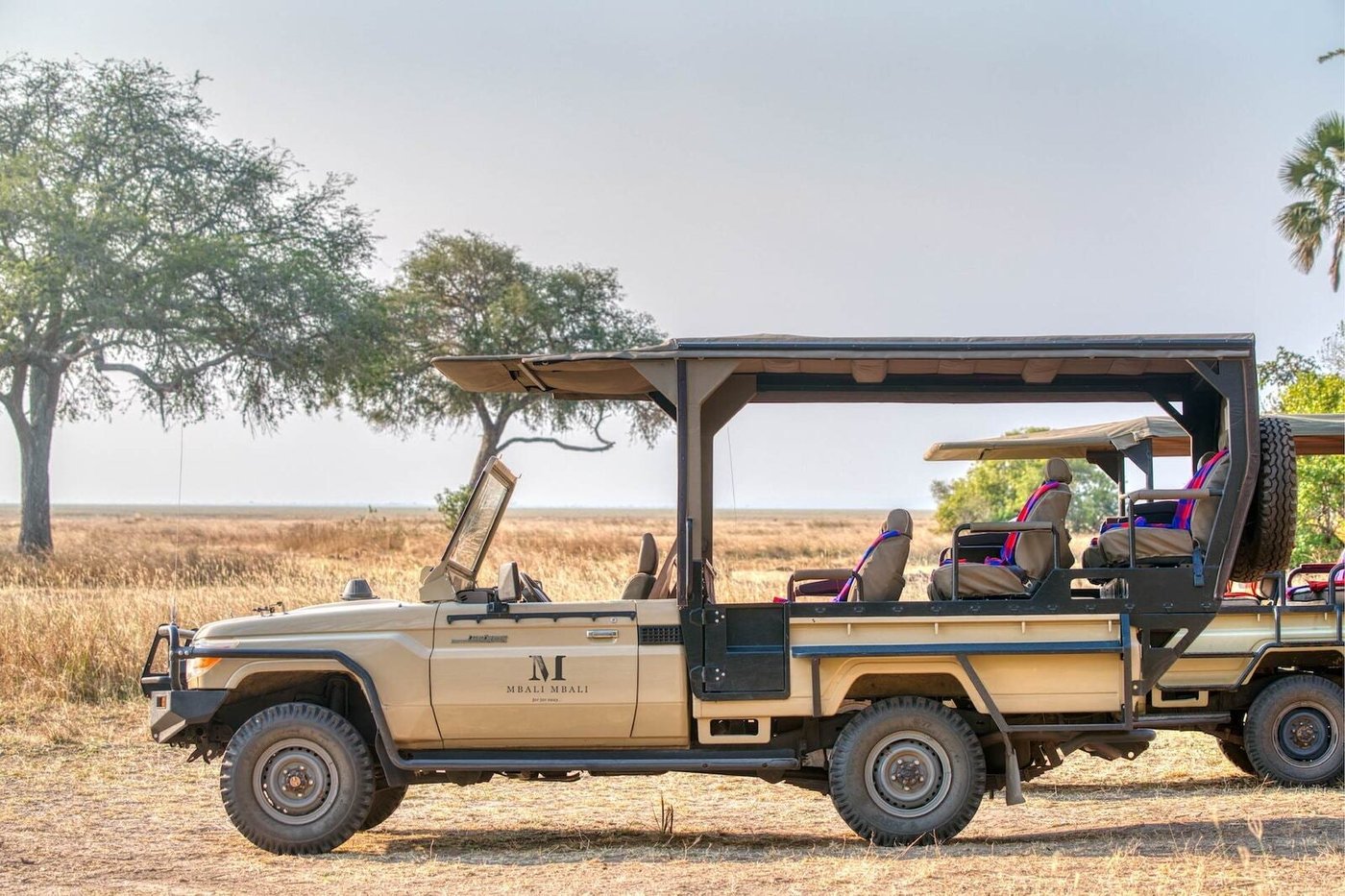 Ein offenes Safari-Fahrzeug auf der Ebene geparkt in Mbali Mbali Katavi Lodge